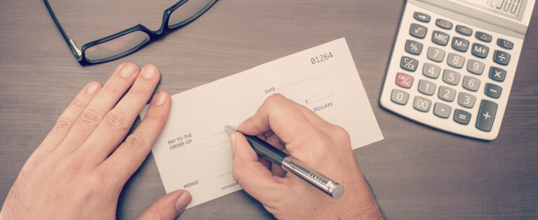 a person with a pen and a calculator on a desk.