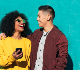Diverse couple laughing with cell phone